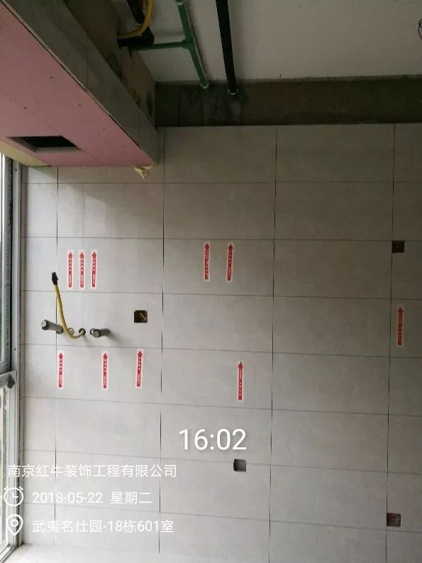 南京武夷名仕園124平米簡美風格裝修  享受家帶來的溫度30五月份_墻磚鋪貼完成后，紅牛裝飾的工人會用專用護角條對瓷磚角保護，用標貼標出水管、線管走向示意。